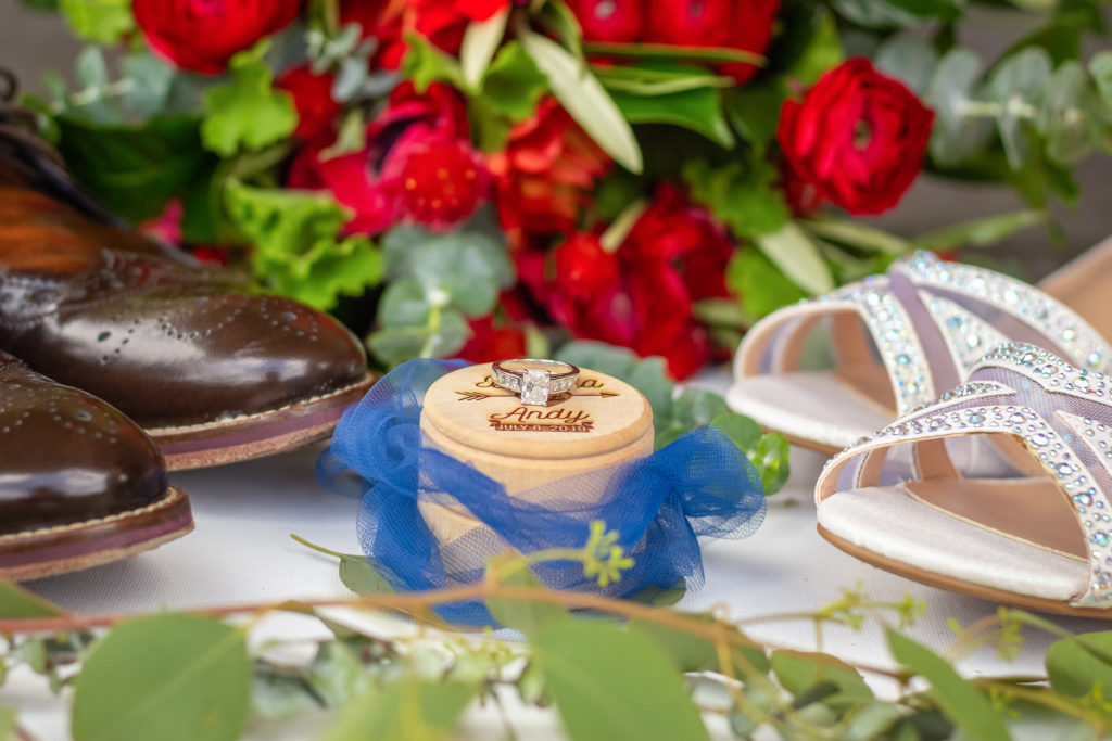 wedding detail flat lay with ring and ring boxes flowers and details