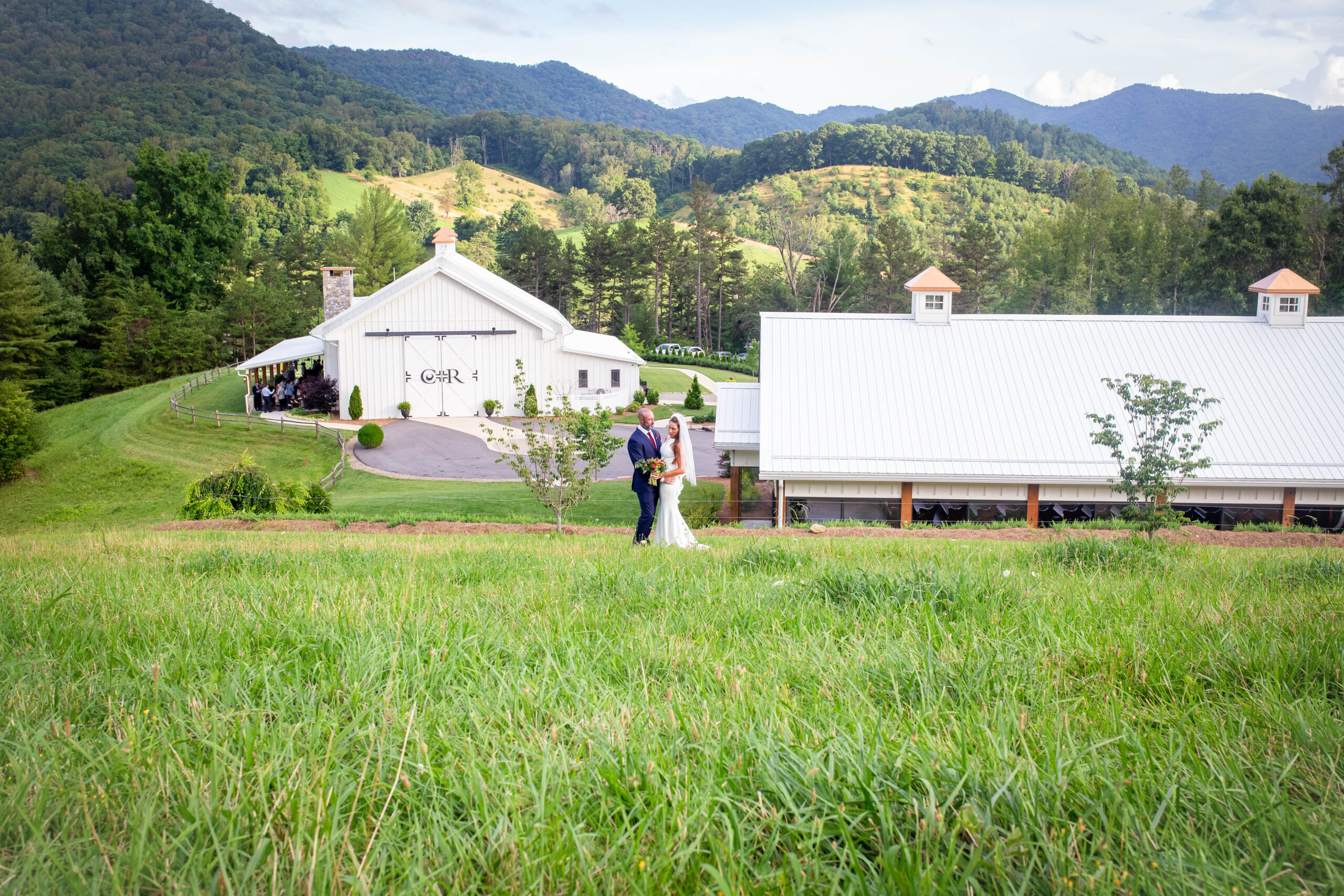 A Bride and Groom stand on a mountain side overlooking the Chestnut Ridge venue in Canton NC. 