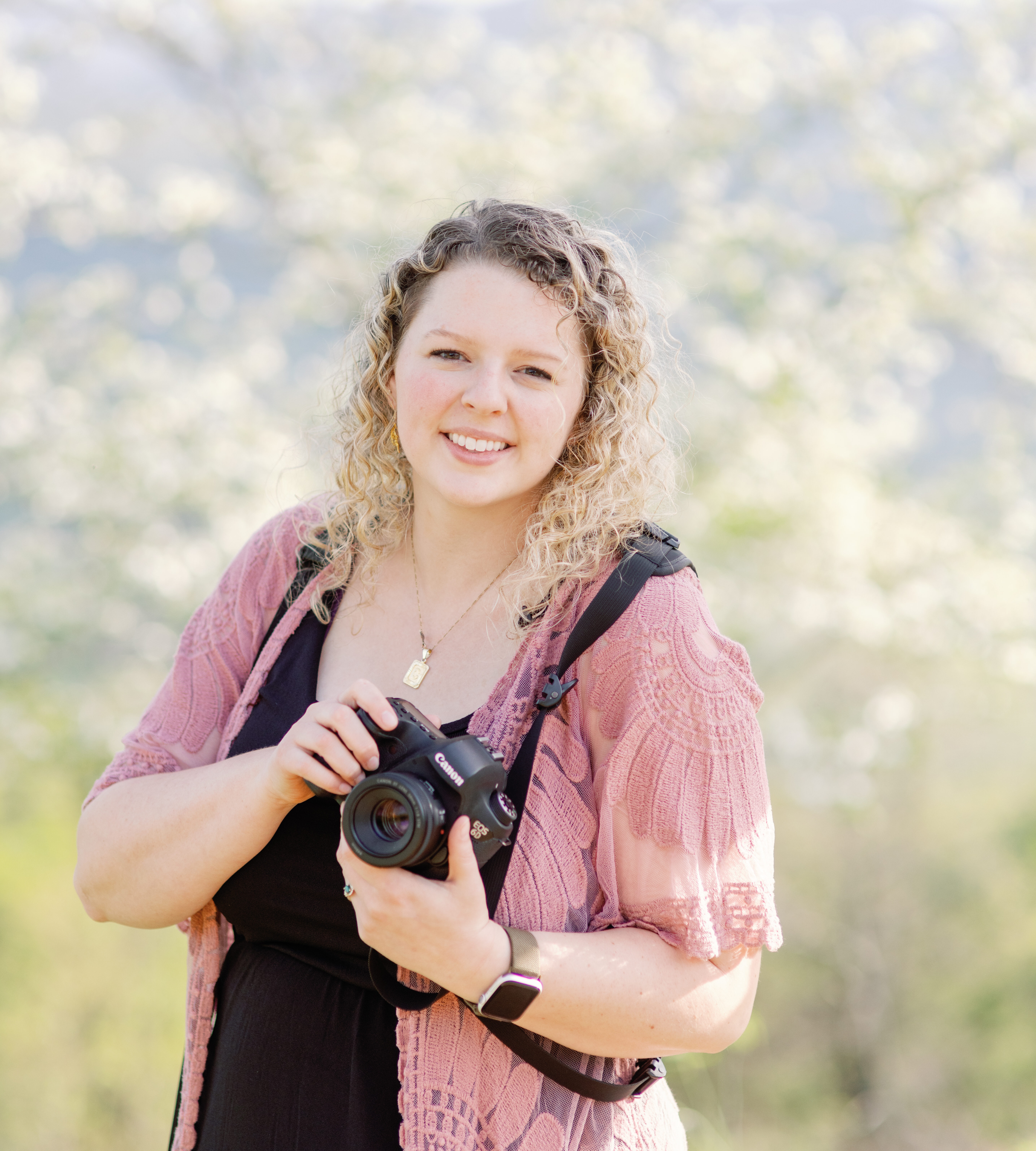 Hi it's me your friendly Denver NC wedding photographer carra, this is a photo of me from 2023 in the mountains of north carolina holding one of my cameras!